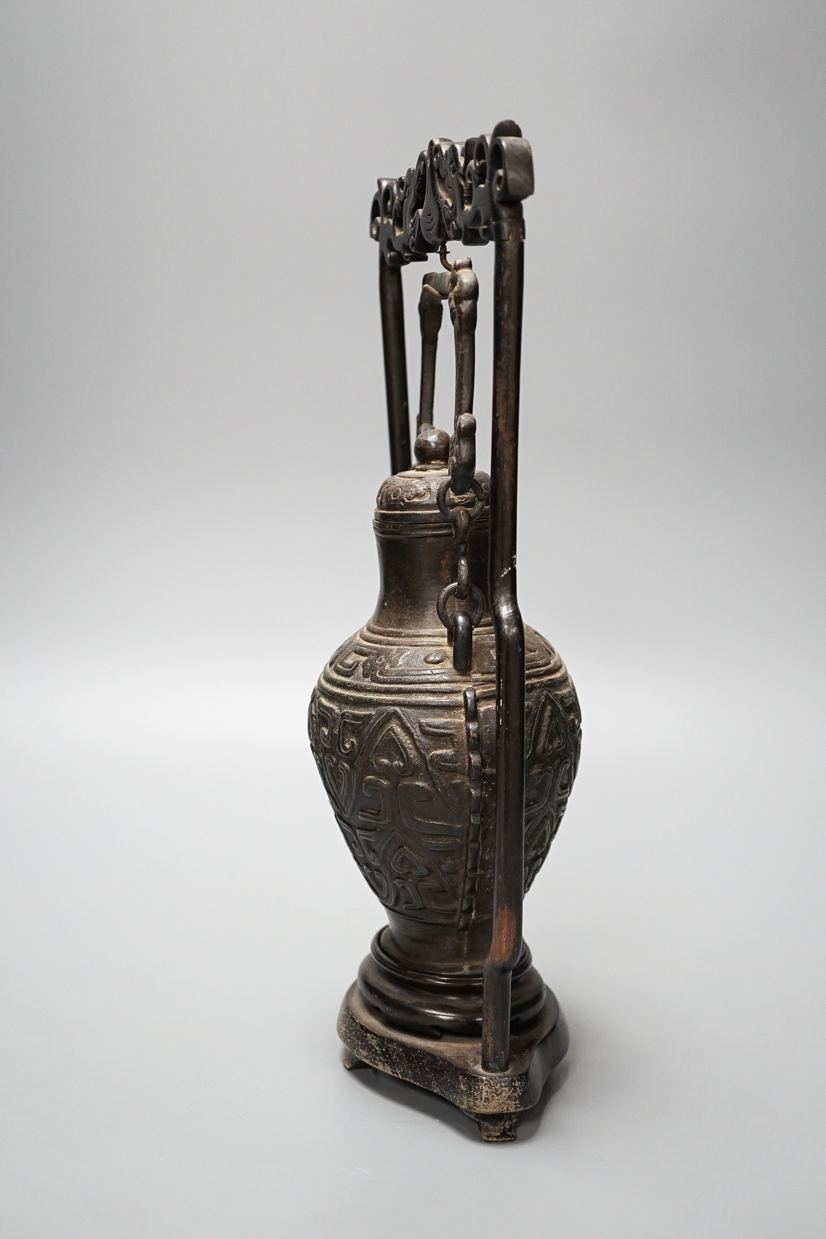 A Chinese archaistic bronze hanging vessel, wood stand 34cm